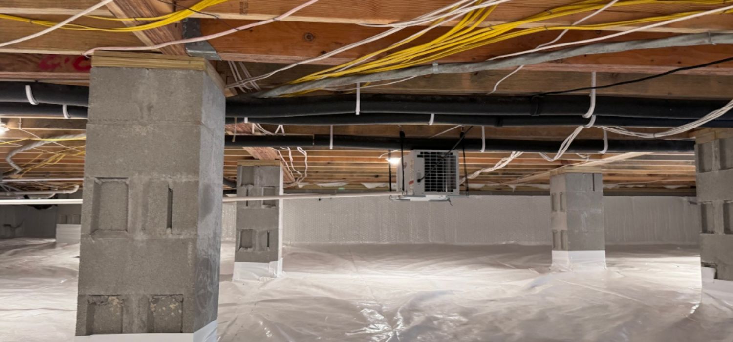 Encapsulated crawlspace with sealed vapor barrier, concrete block support piers, and installed dehumidifier to control moisture under a home.